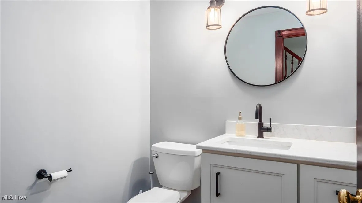 Half bathroom featuring vanity and toilet