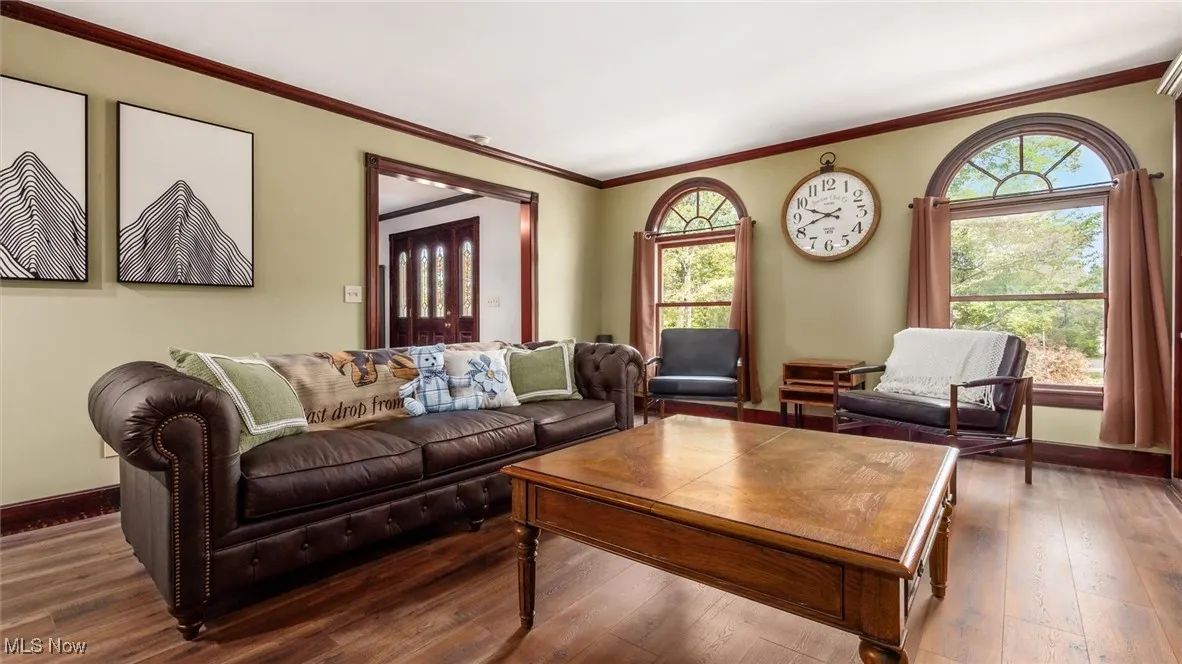 Living area with ornamental molding, hardwood / wood-style flooring, and plenty of natural light