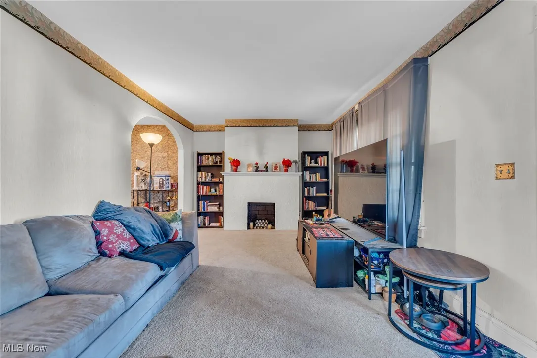 Living area with a fireplace and carpet