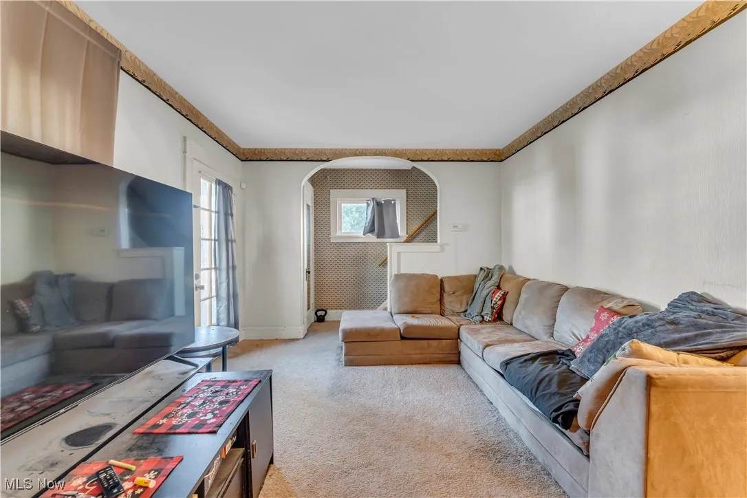 Living area with light carpet and baseboards