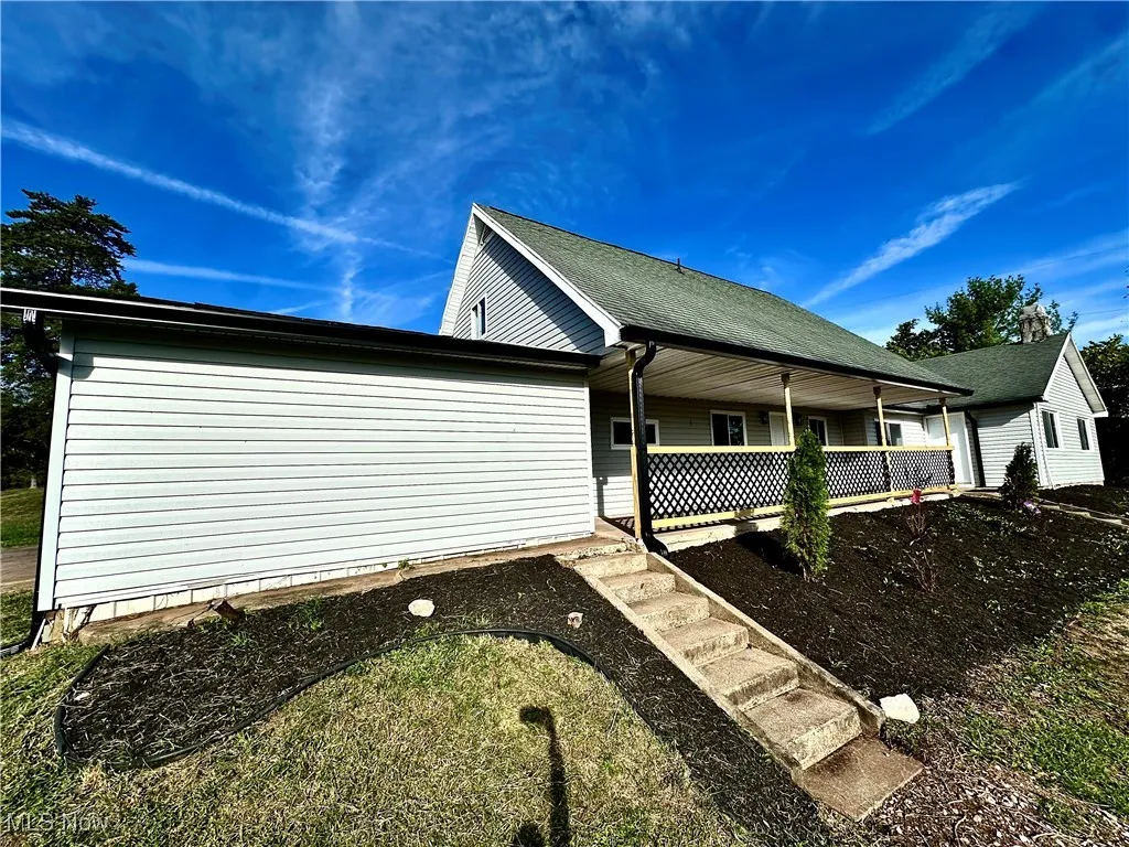 View of property exterior featuring a porch