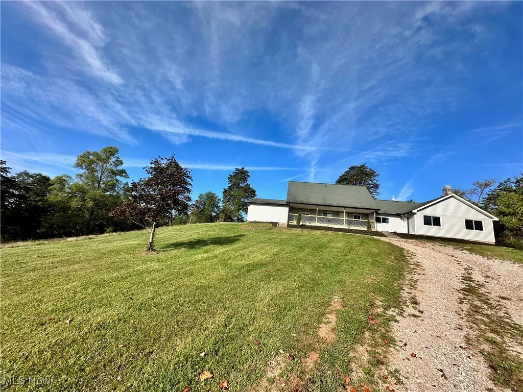 View of front of house featuring a front yard, a patio area, and driveway