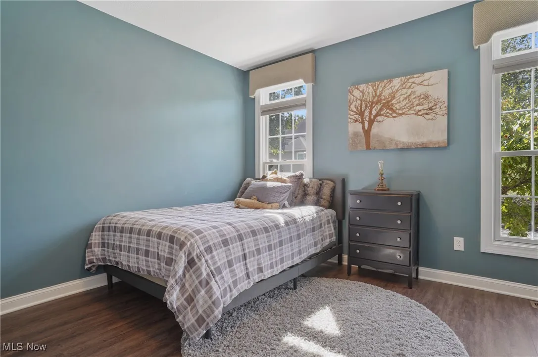 Bedroom with multiple windows and dark wood finished floors