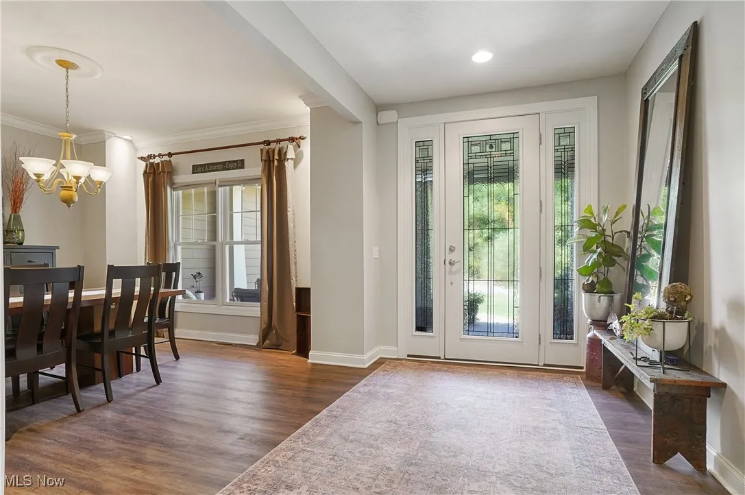 Entryway featuring wood finished floors and a chandelier