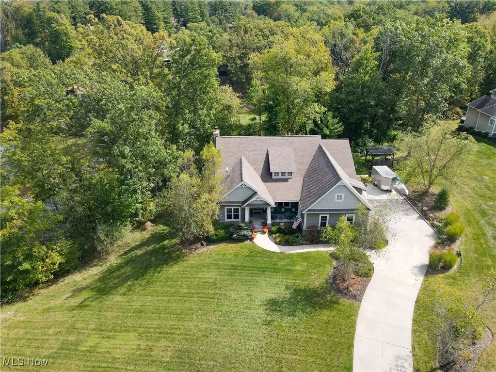 Aerial view of property and surrounding area featuring a forest