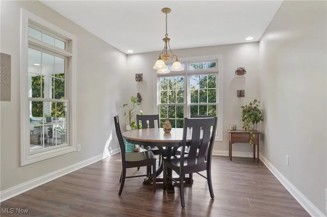 Dining space with dark wood finished floors and recessed lighting