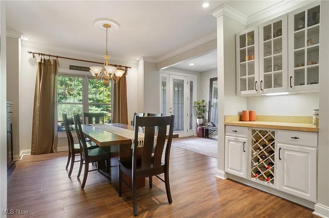 Dining area featuring light wood-type flooring, ornamental molding, recessed lighting, and a chandelier