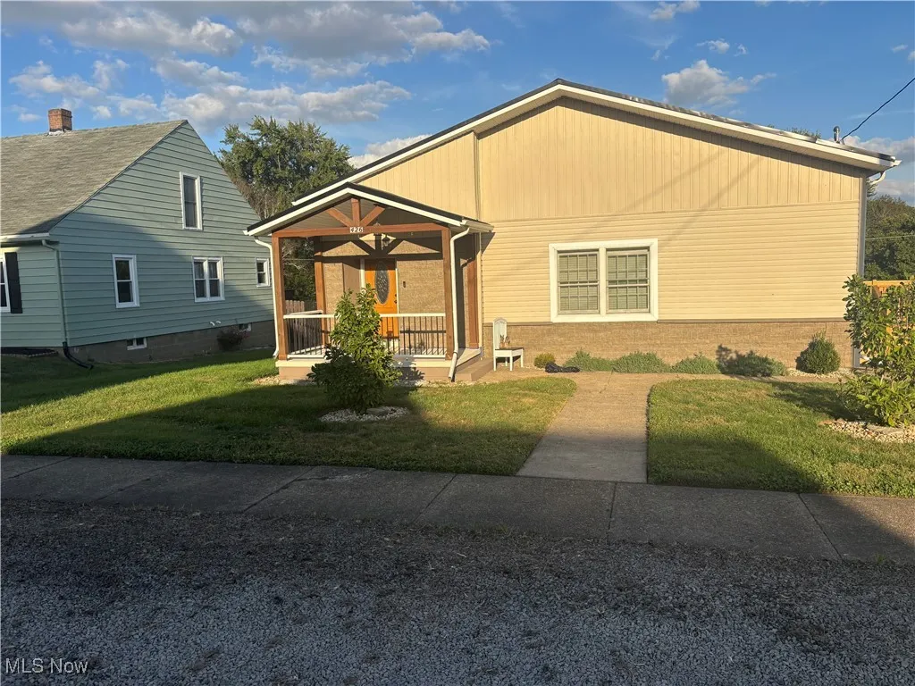 View of front of property featuring covered porch and a front yard