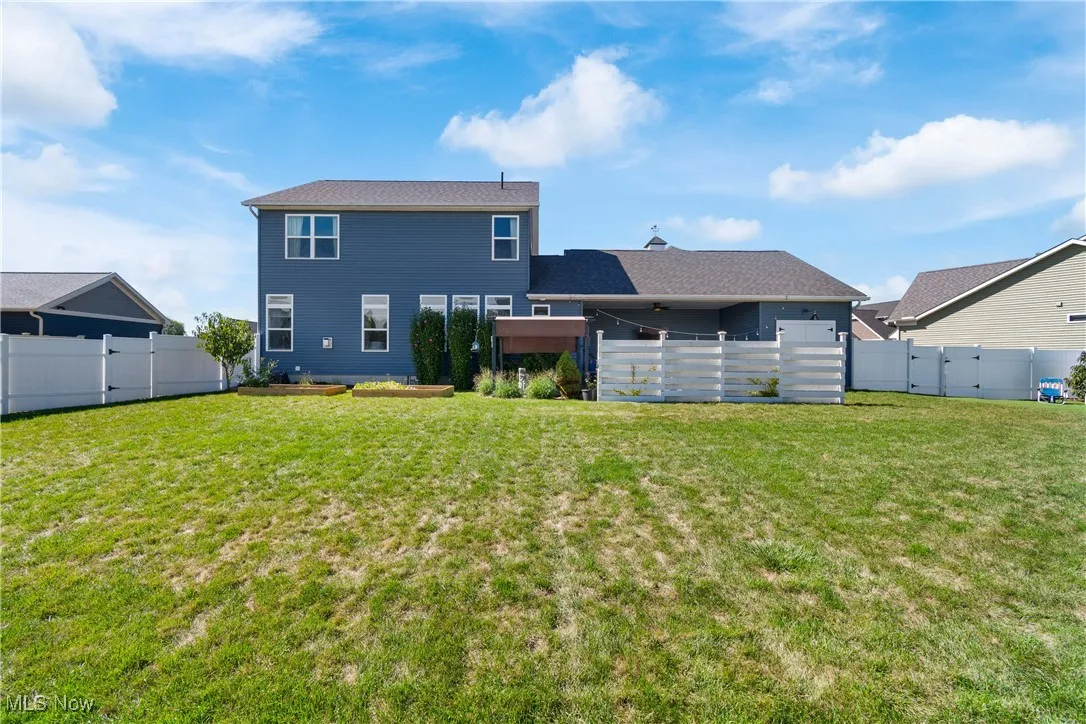 Rear view of house featuring a fenced backyard