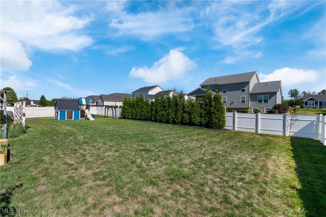 Fenced backyard with a playground and a residential view
