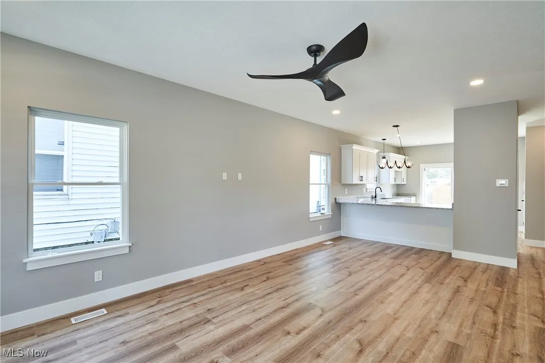 Unfurnished living room featuring sink and light wood-type flooring