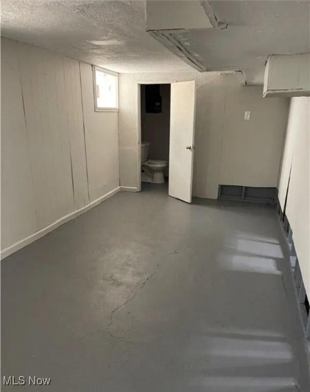 Below grade area featuring a textured ceiling and wood walls