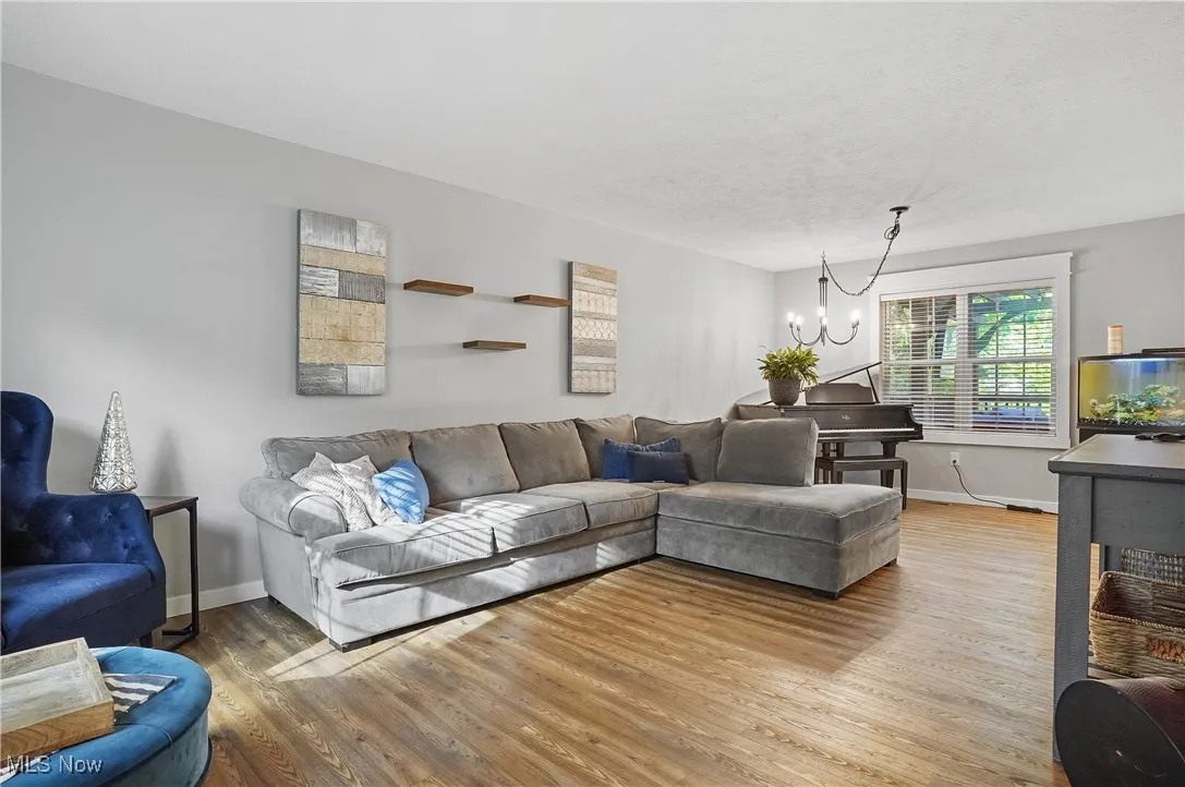 Living area with wood finished floors, a chandelier, and a textured ceiling