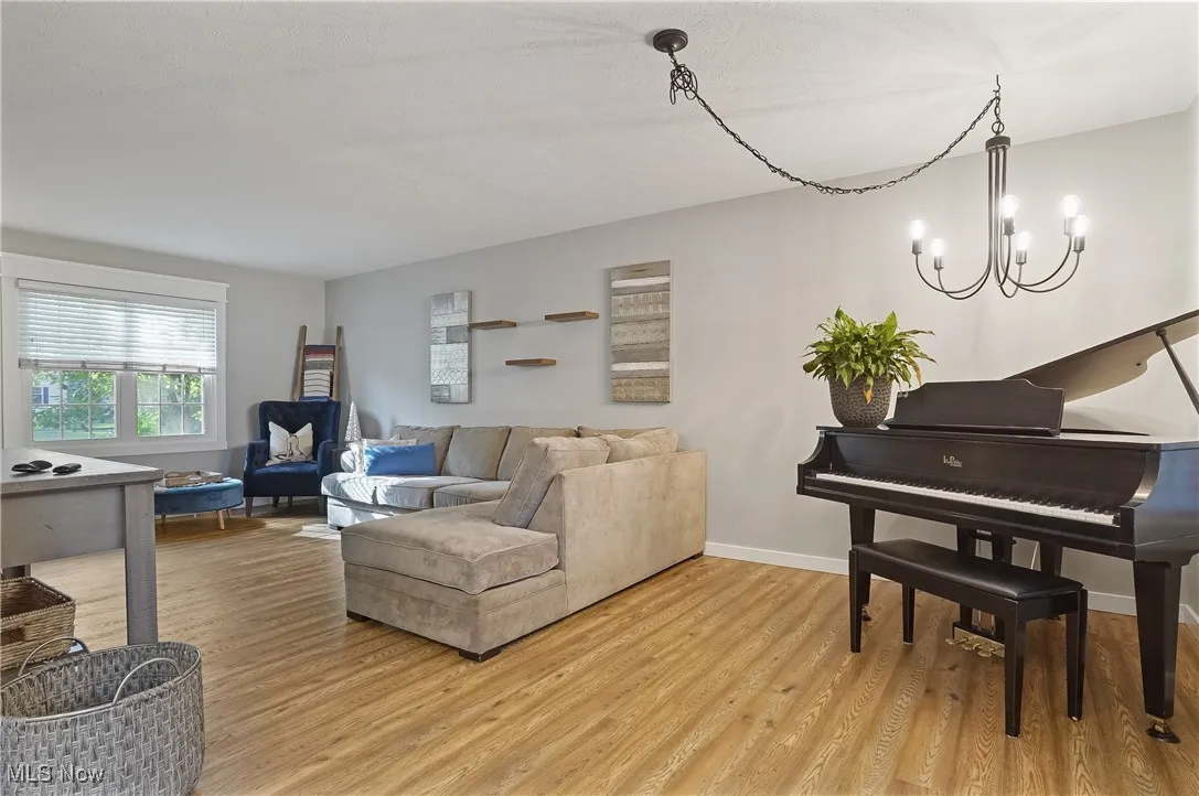 Living area with light wood lvt floors and a chandelier