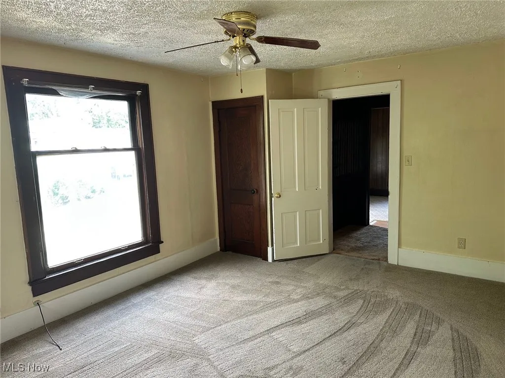 Unfurnished bedroom with carpet floors and a textured ceiling