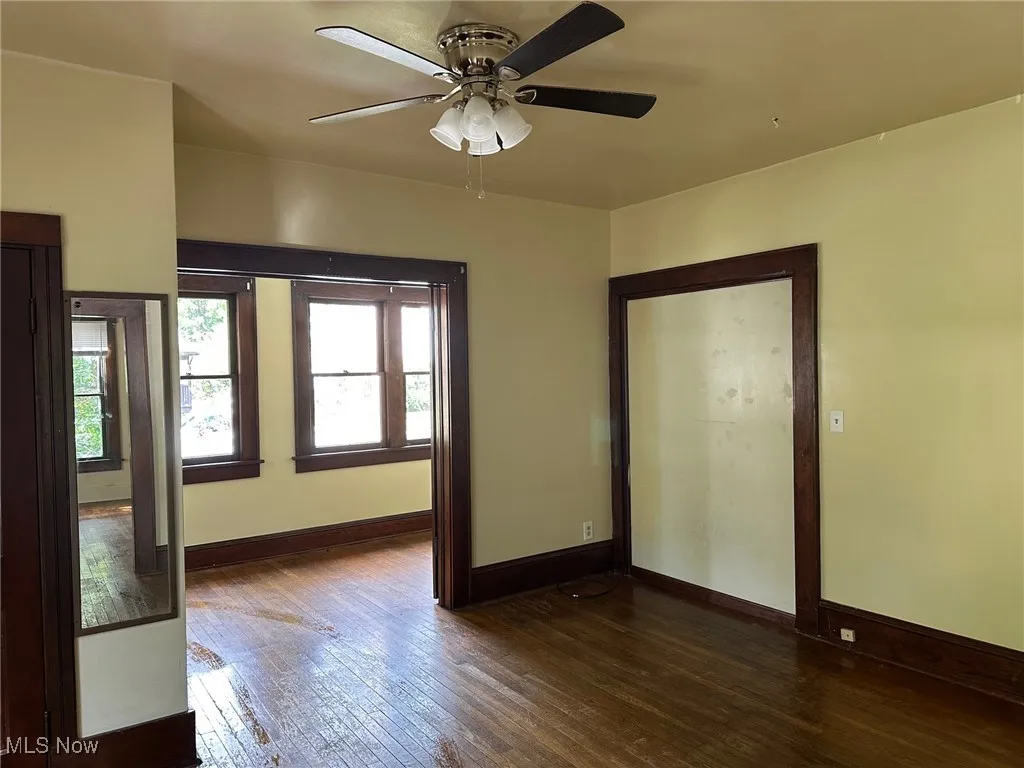Unfurnished room featuring dark wood finished floors and ceiling fan