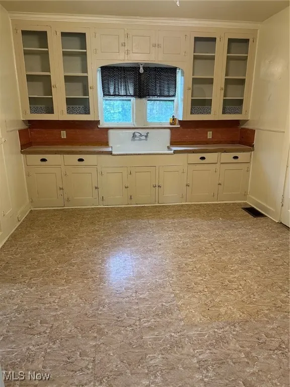 Kitchen with glass insert cabinets and a sink