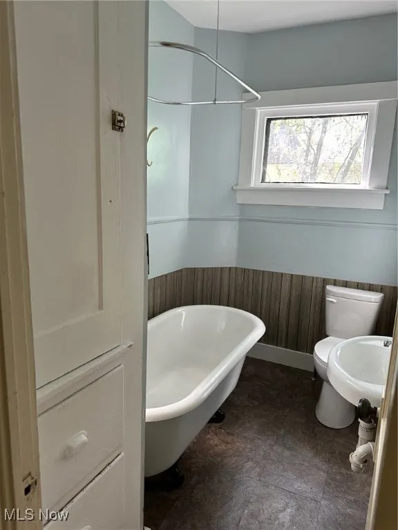 Bathroom with toilet and a wainscoted wall