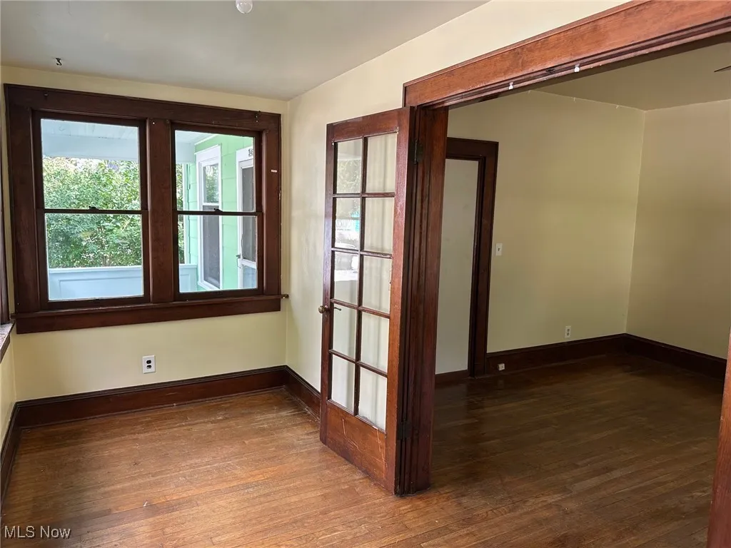 Spare room featuring dark wood-style floors and plenty of natural light