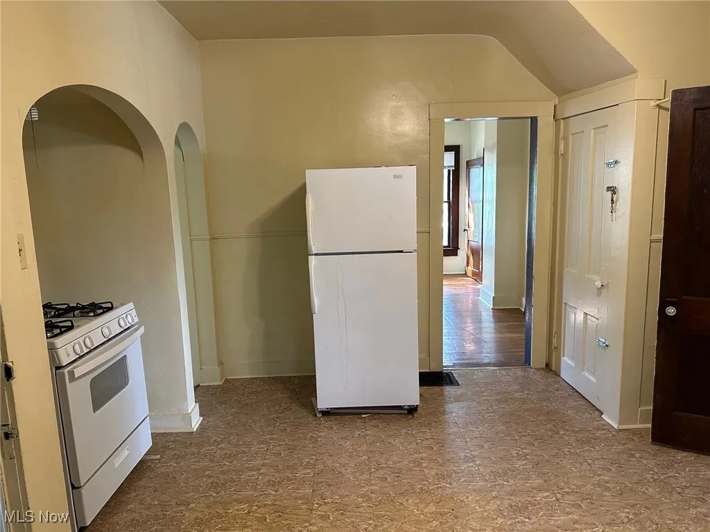 Kitchen with white appliances and baseboards