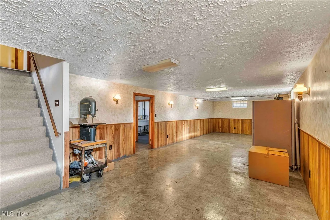 Basement with entryway to storage, partial bathroom, and utility/laundry room with workshop space