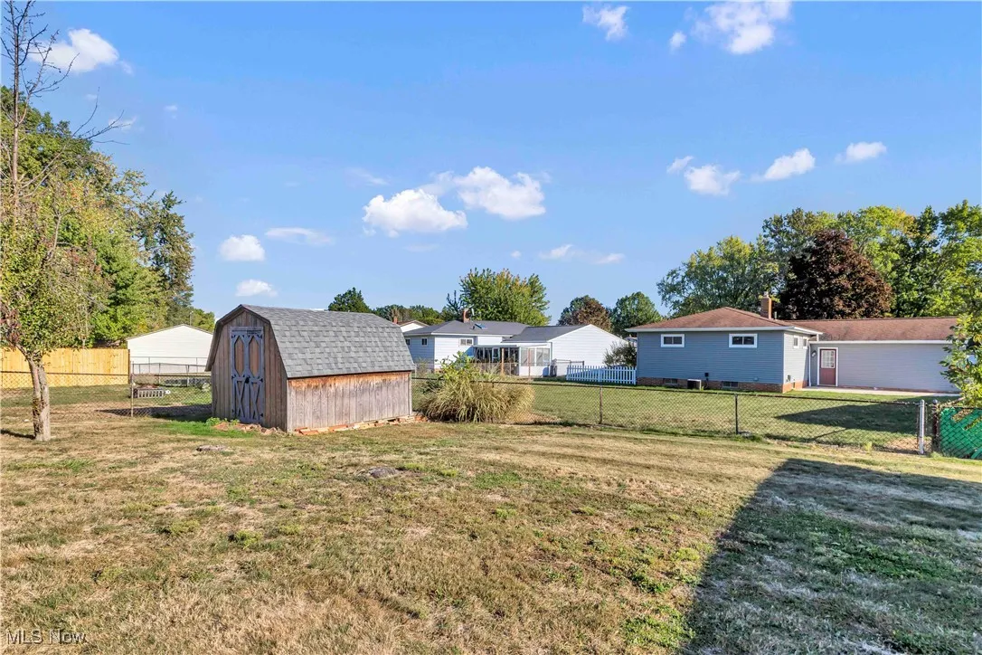 Partially fenced-in backyard with a shed
