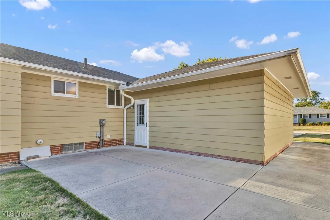 Rear view of house featuring a paved patio area