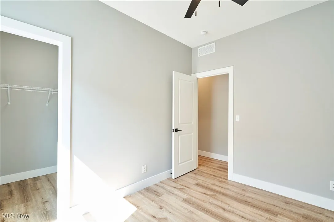 Unfurnished bedroom featuring a closet, light wood-type flooring, and ceiling fan