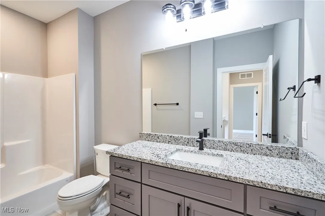 Full bathroom with vanity, toilet, and shower / washtub combination