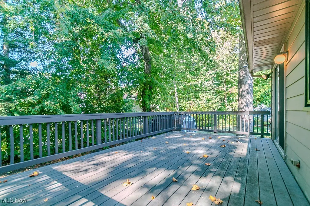 Wooden terrace featuring view of wooded area