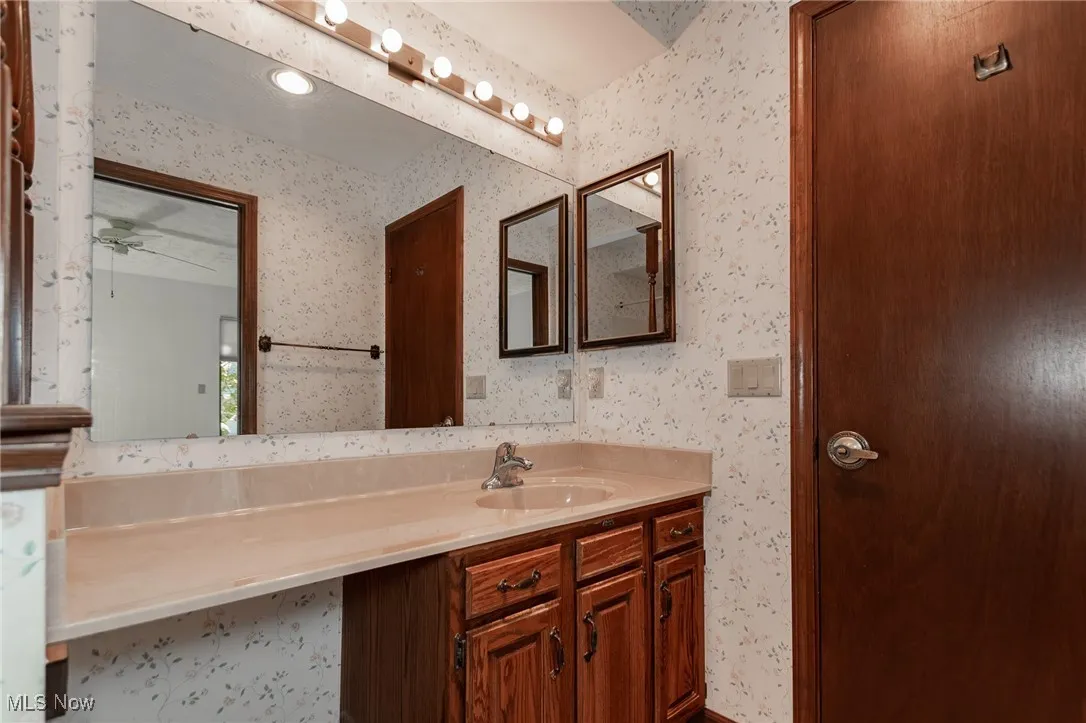 Bathroom featuring vanity and wallpapered walls