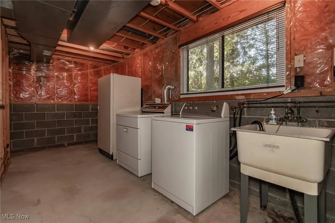 Laundry room featuring concrete floors and washing machine and clothes dryer