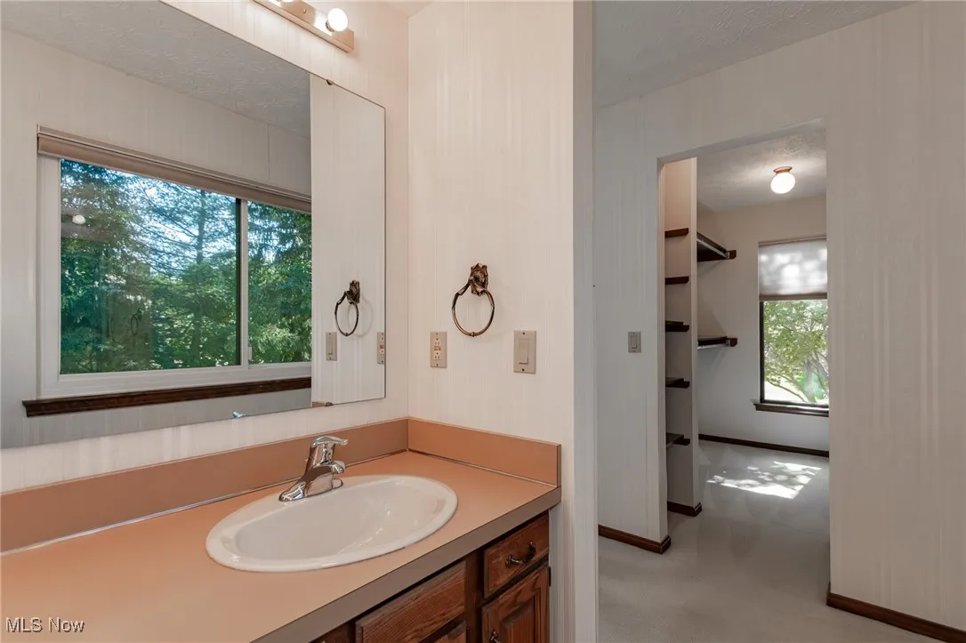 Bathroom featuring vanity, light colored carpet, and a textured ceiling