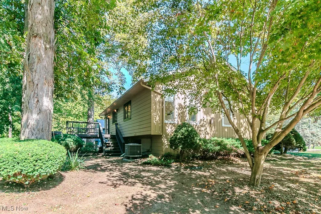 View of side of home with stairway and a deck