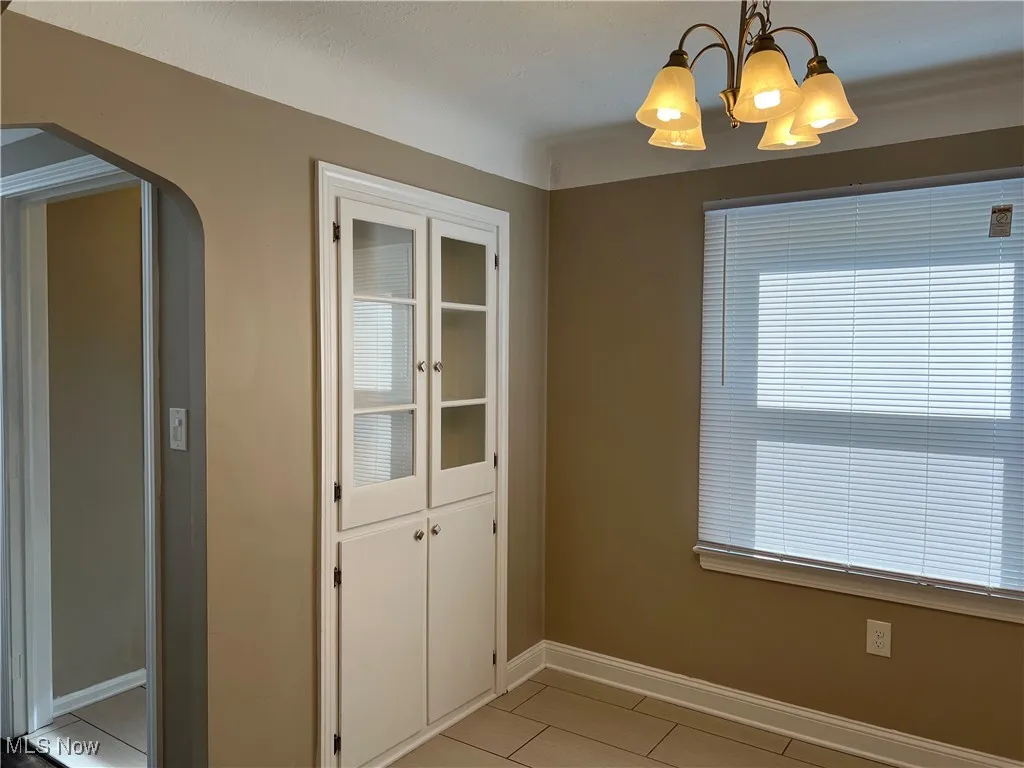  Off kitchen is dining  room with arched walkways, and chandelier
