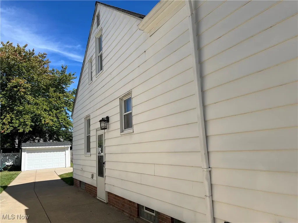 View of home's exterior with an outbuilding, a garage, and crawl space
