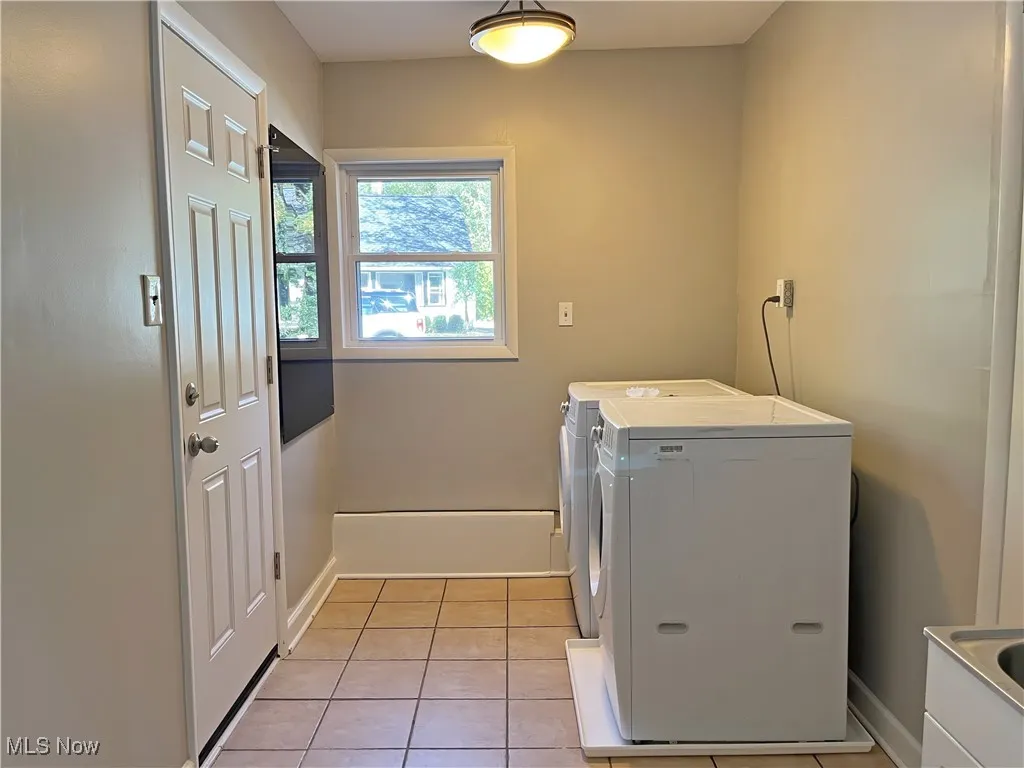 Laundry room featuring light tile patterned flooring and separate washer and dryer