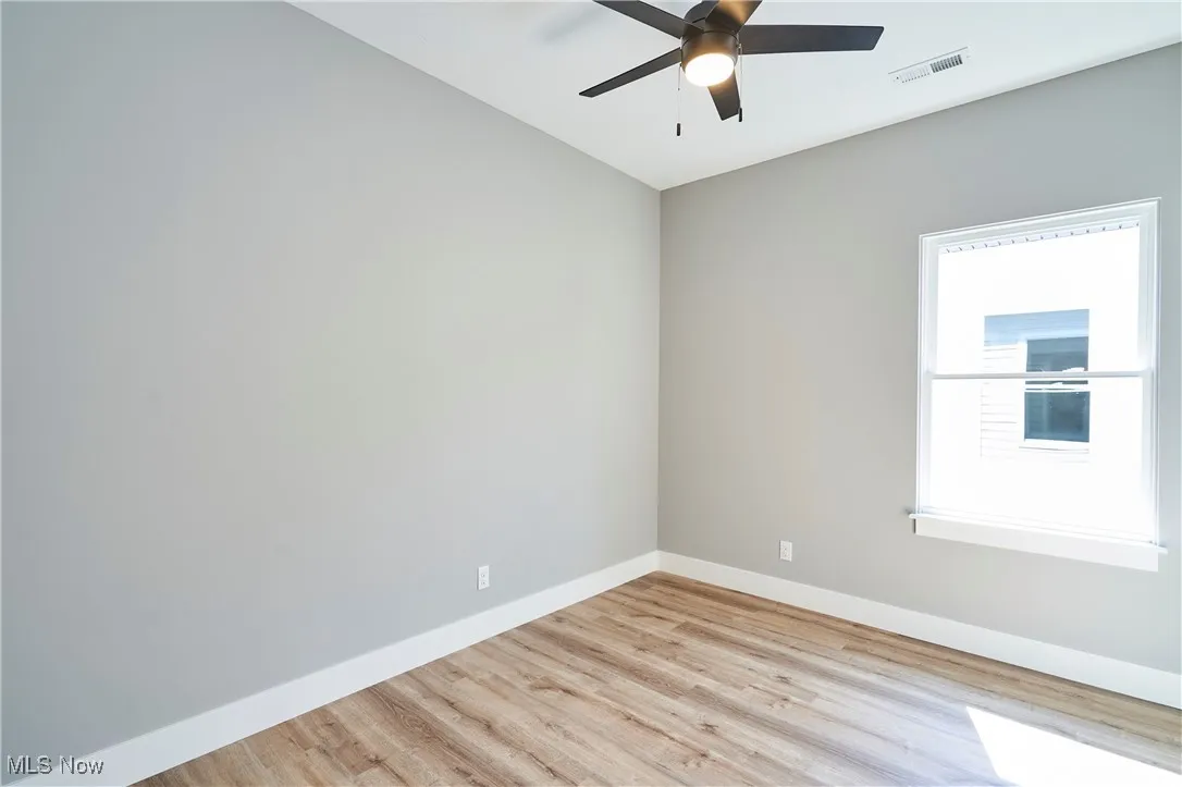 Unfurnished room featuring light wood-type flooring and ceiling fan
