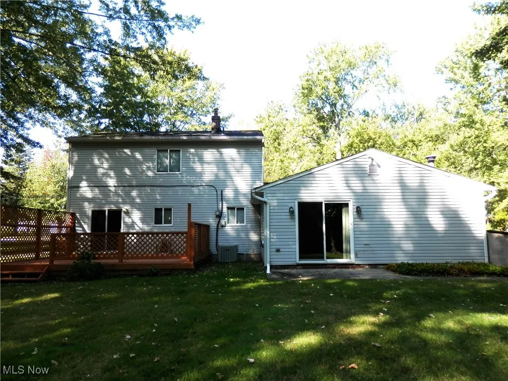 Back of property with a yard, a patio, and a deck