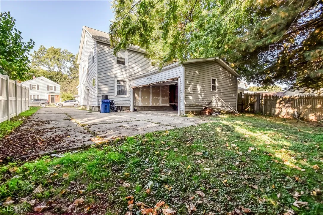 Back of house with a garage and a patio