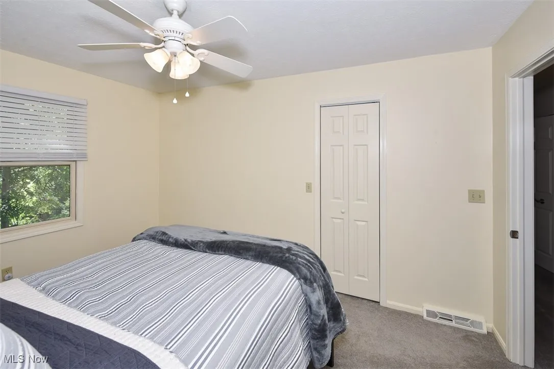 Bedroom with carpet floors, a ceiling fan, and a closet