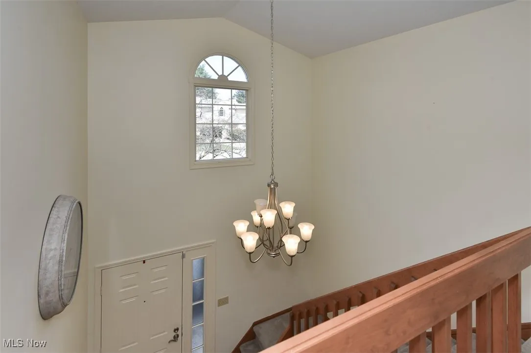 Entryway with a chandelier and vaulted ceiling