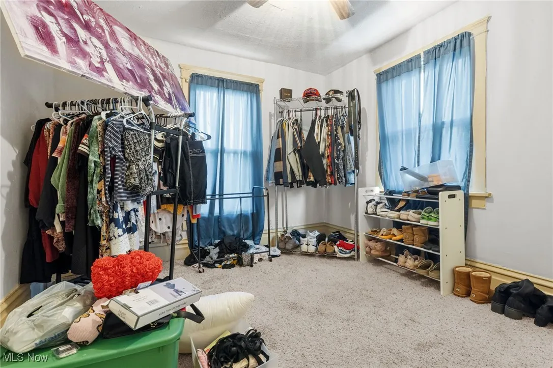 Spacious closet with carpet floors and a ceiling fan