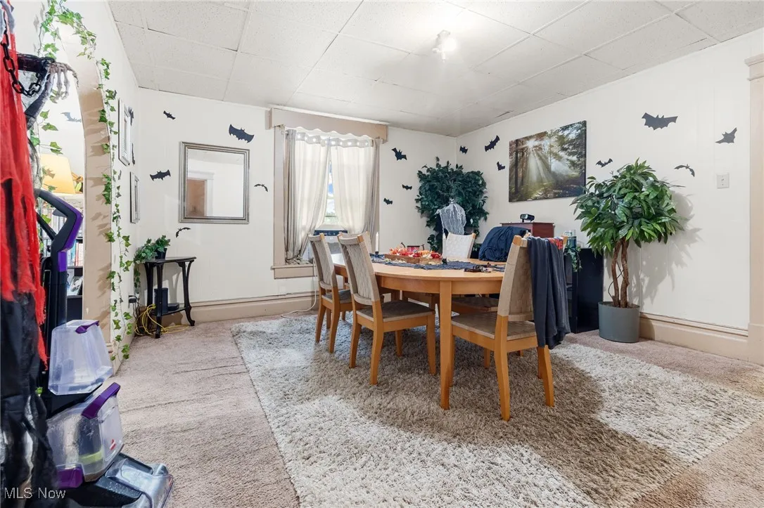 Carpeted dining area with a drop ceiling