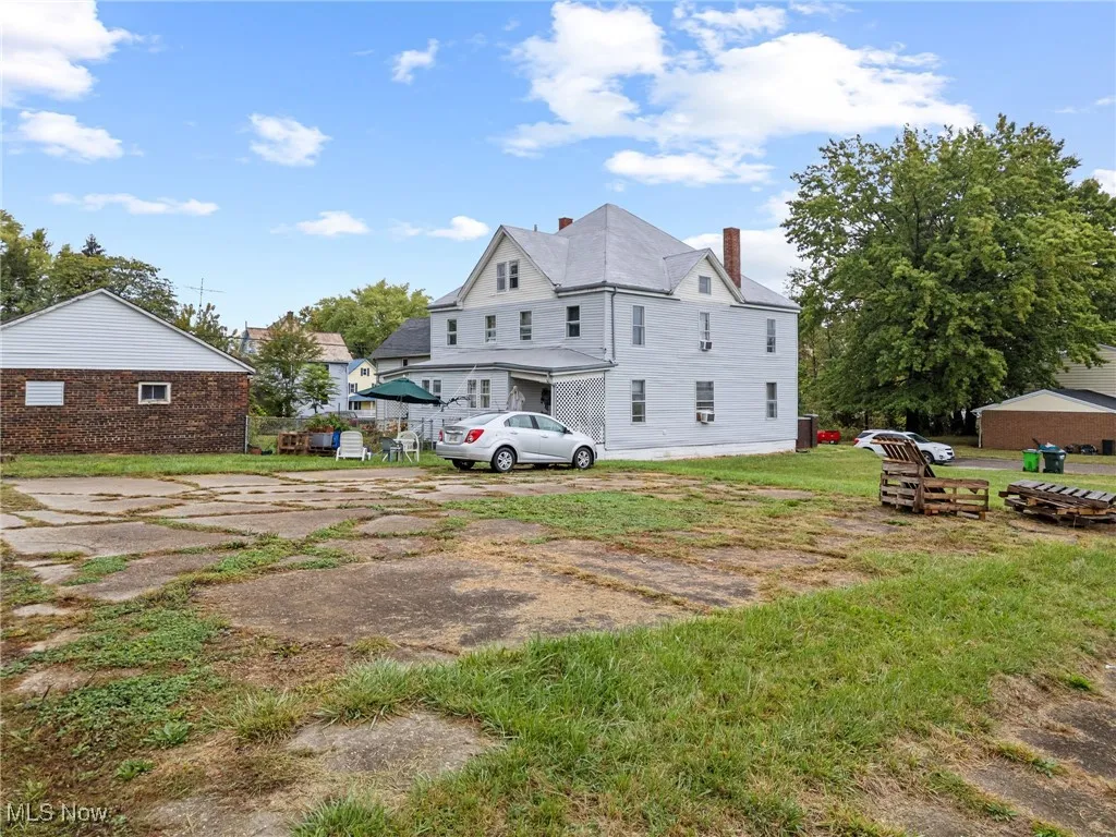 Back of property with a chimney and a yard