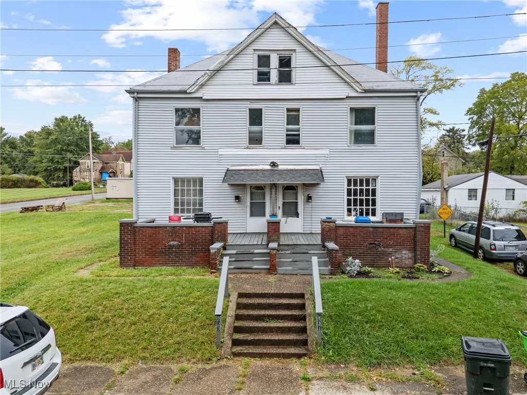 View of front facade with a chimney and a front yard
