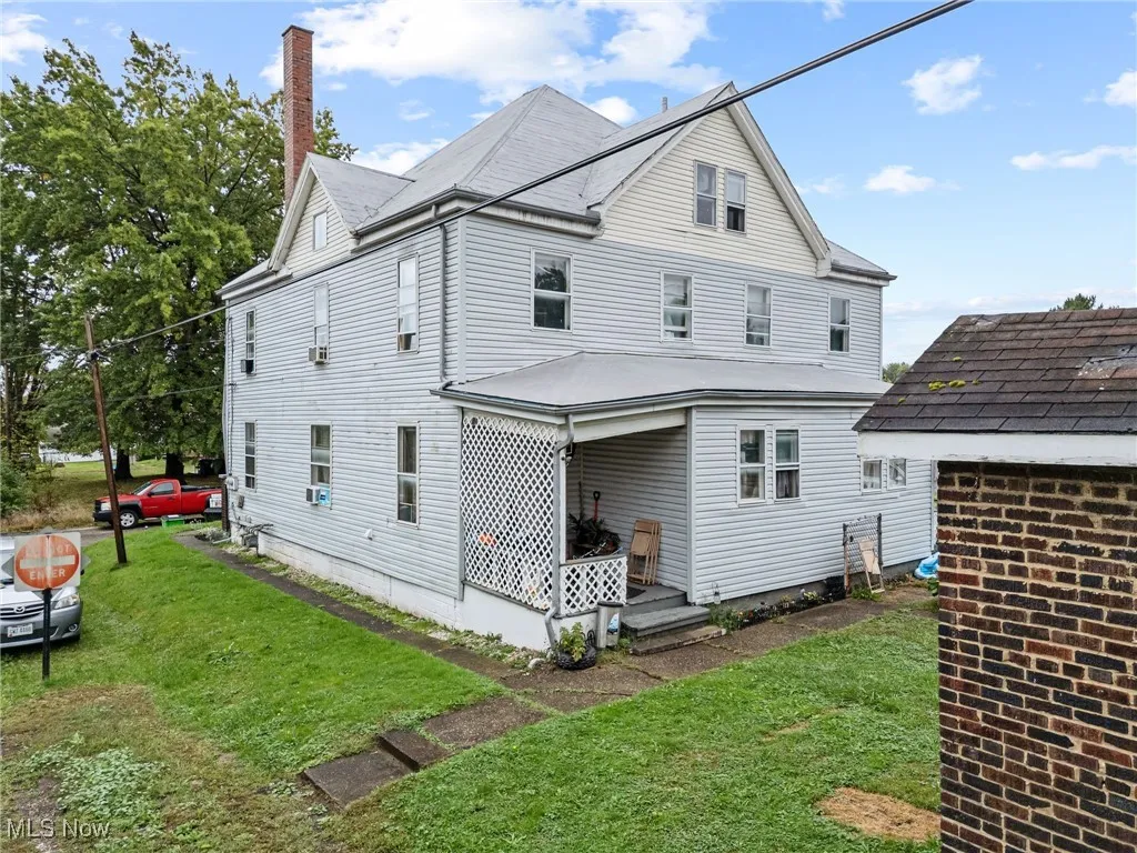 Back of house with a lawn