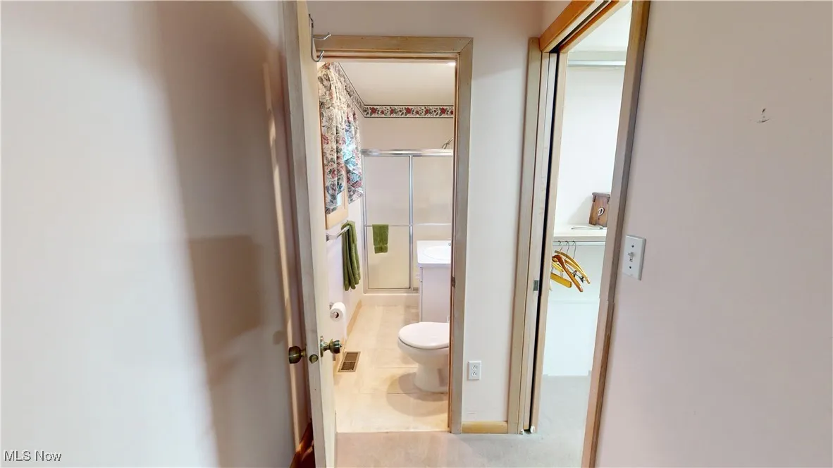 Primary bedroom hallway to full bath and large closet.