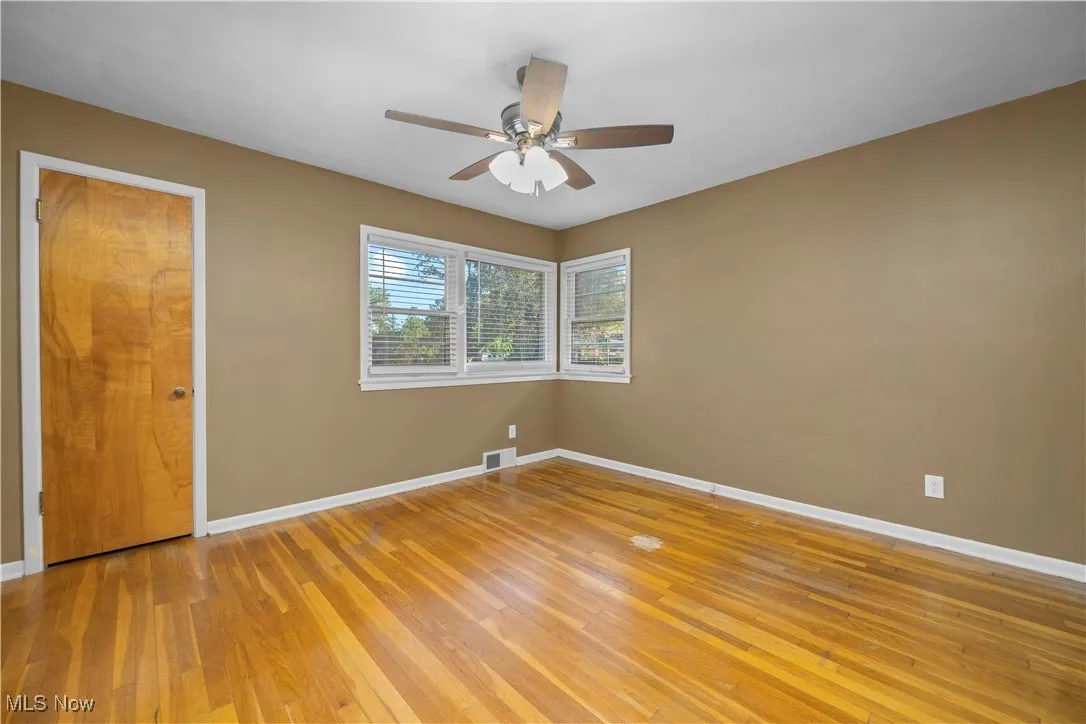 Empty room with light wood-style flooring and ceiling fan