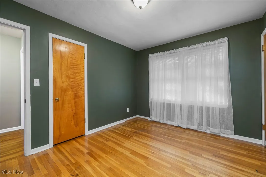 Spare room featuring baseboards and light wood finished floors